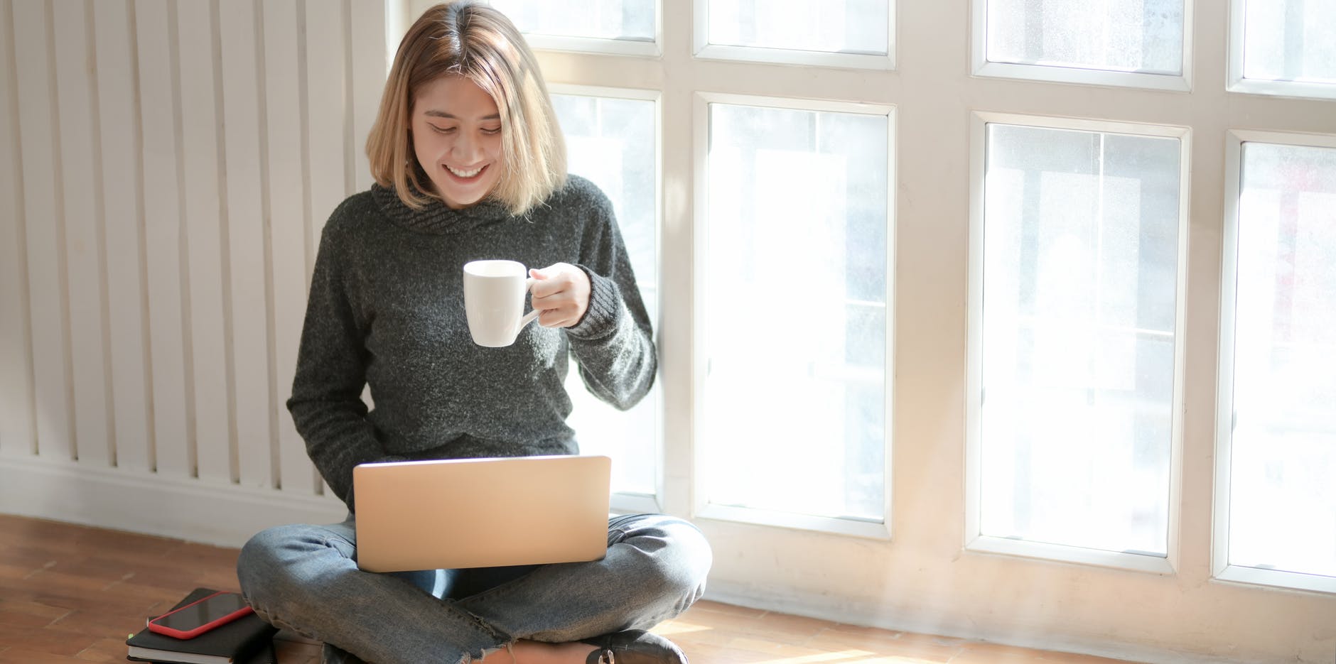 woman in gray sweater drinking coffee